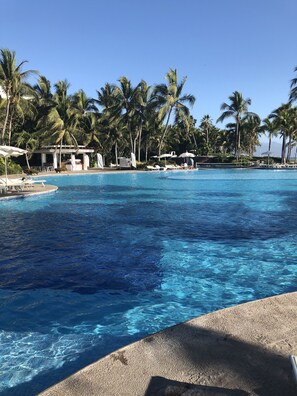 A clear blue pool surrounded by palm trees and lounge chairs. - 3-Bedroom Vidanta Grand Luxxe (Nuevo Nayarit)