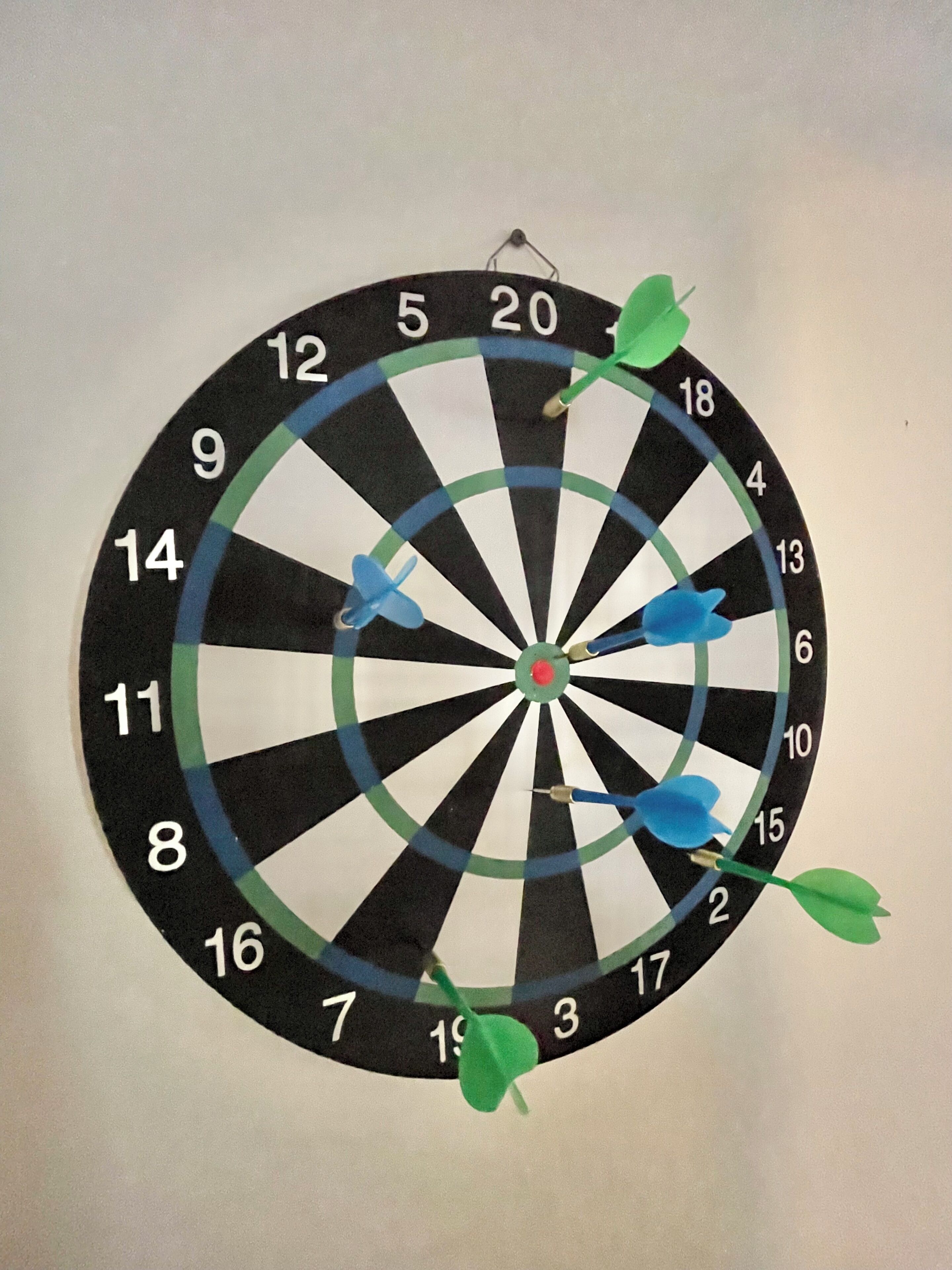 A dartboard with multiple darts stuck in it.