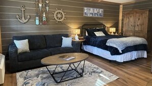 Une pièce comprenant un lit, un canapé, une table basse et des éléments de décoration murale sur le thème de la marine.