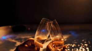 Deux mains tenant des coupes de champagne.