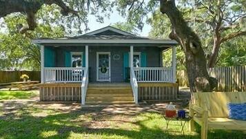 A single-story house with a porch, a front door, and a small front yard.