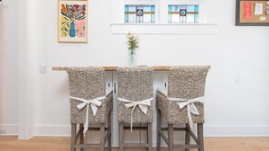 A dining area with a wooden table and three wicker chairs tied with white ribbons. - 3bedroom/2bath home with Private Pool! Downtown St Augustine, quiet and walkable (St. Augustine)