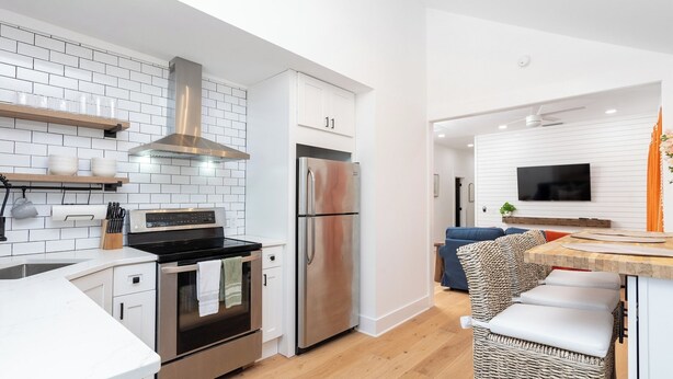 A modern kitchen with white cabinetry, stainless steel appliances, and a built-in oven. - 3bedroom/2bath home with Private Pool! Downtown St Augustine, quiet and walkable (St. Augustine)