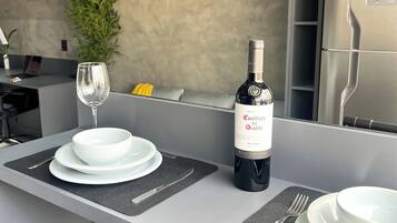 Uma cozinha moderna com uma garrafa de vinho, copos e pratos sobre o balcão.
