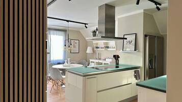 A modern kitchen with a central island, built-in appliances, and pendant lighting.