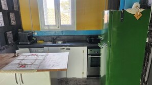 A kitchen with a white refrigerator, a green freezer, a sink, and a window. - jim vila (Andravida)
