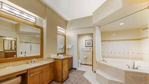 Un baño moderno con un espejo grande, un tocador doble, una zona de ducha separada y una bañera.