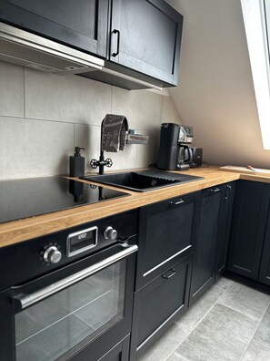 Een koelkast, een oven, een kookplaat, een vaatwasser