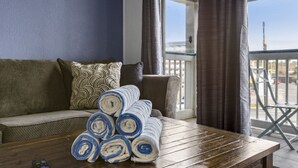 Ein gemütliches Zimmer mit Holztisch, einer Couch und Blick ins Freie.