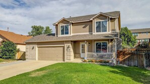 A two-story house with a garage, a front porch, and a well-maintained lawn. - Front Range Getaway - 4 beds with Jacuzzi (Colorado Springs)