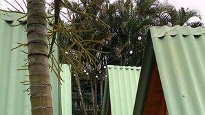 A pathway with a colorful hexagonal tile floor leading to a wooden structure with a green roof. - 4 Elements Inn Guarujá (Guarujá)