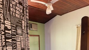 A bedroom with a bed, a ceiling fan, a window with curtains, and a door. - 4 Elements Inn Guarujá (Guarujá)