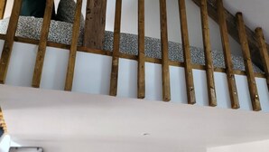 A staircase with wooden railings and patterned cushions. - The wash house (Ballan-Miré)