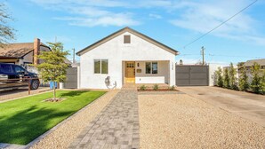 Une maison moderne de plain-pied, dotée d’une porte d’entrée, d’un garage et d’une allée menant à l’entrée.