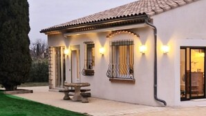 Une maison moderne avec un toit en tuiles, un chemin en pierre et une pelouse bien entretenue.