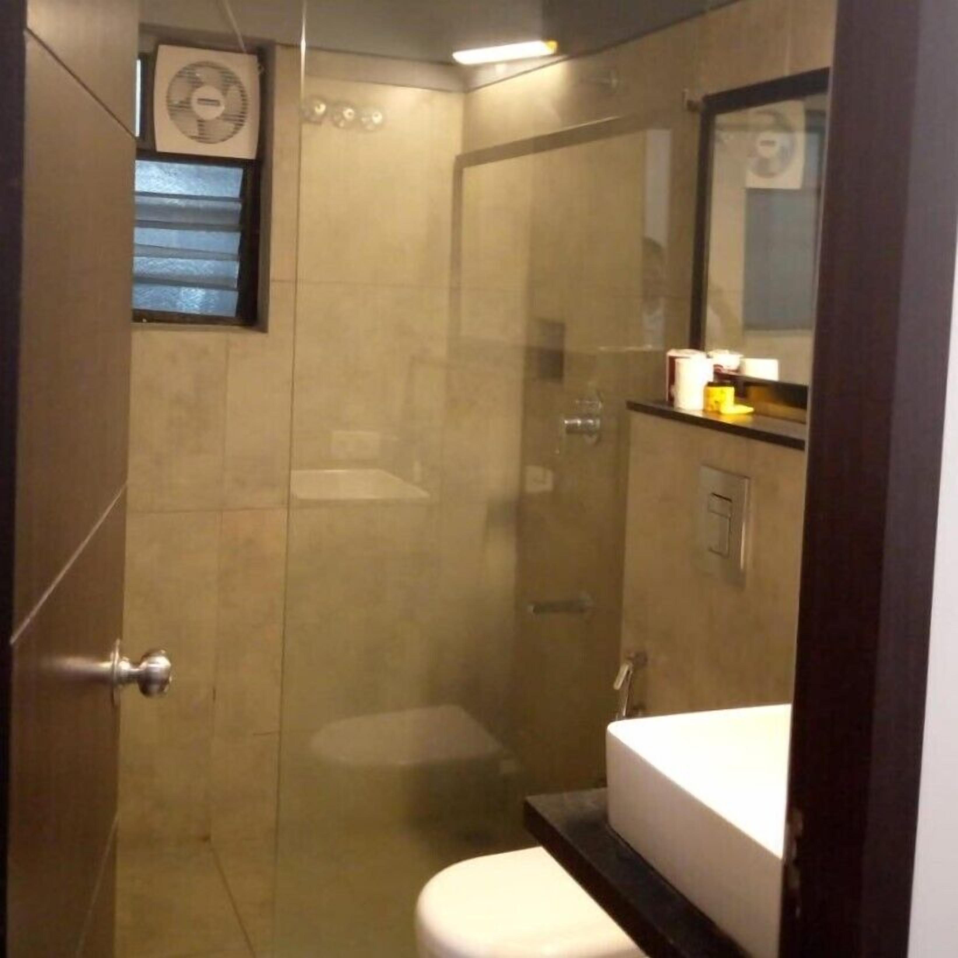 Une petite salle de bain moderne équipée d’une douche, de toilettes et d’un lavabo.