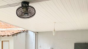 A dining area with a table and chairs, a ceiling fan, and a tiled floor. - Pousada Estilo Brasil (Fortaleza)