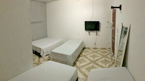 A room with two single beds, a television mounted on the wall, and a coat rack. - Pousada Estilo Brasil (Fortaleza)