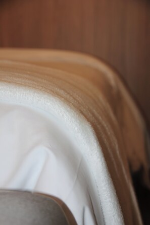 A close-up of a white, textured fabric, likely a part of a piece of furniture or decor.