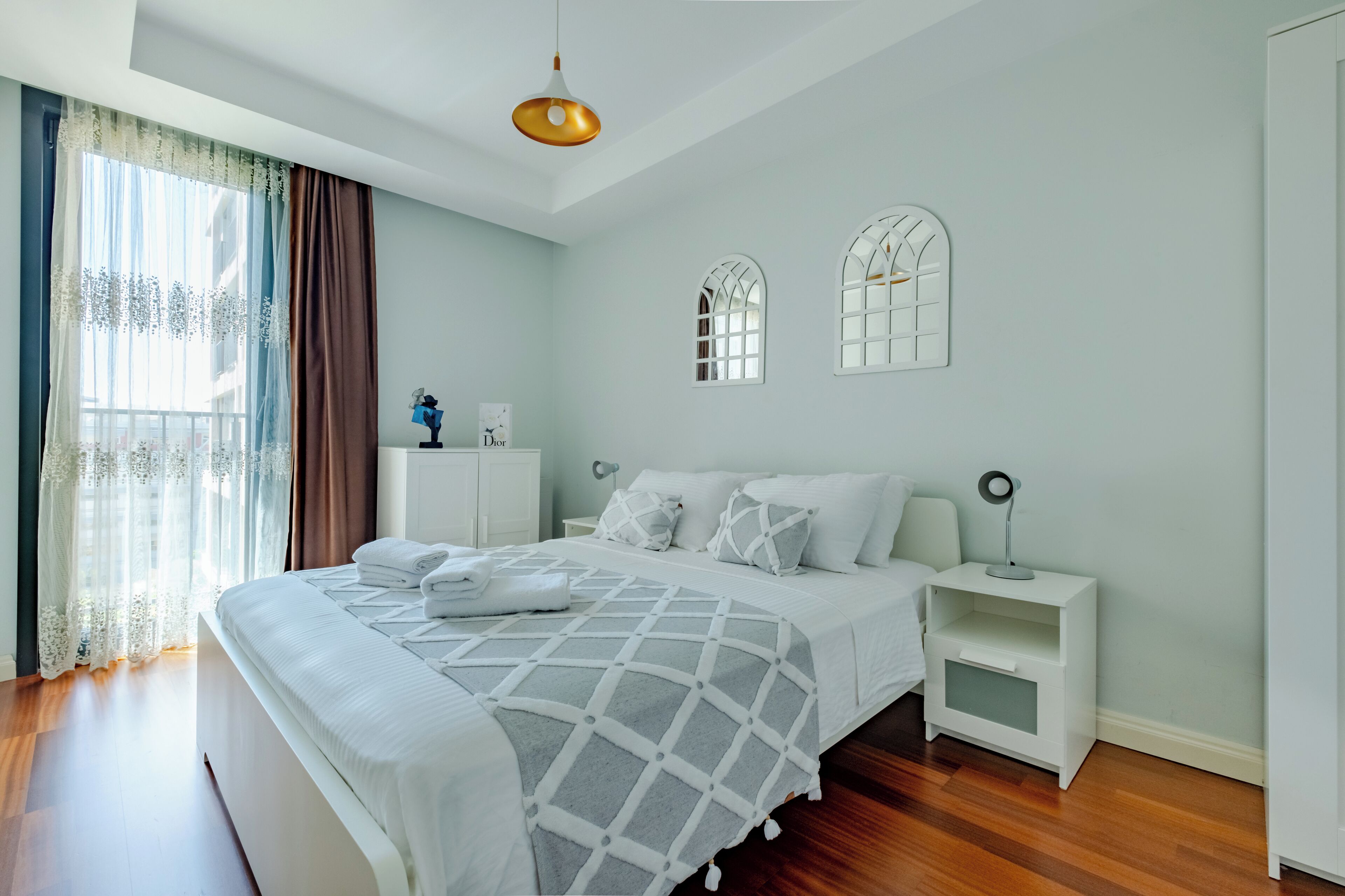 Una camera da letto moderna con un letto grande, comodini bianchi e una lampada a soffitto.