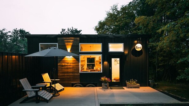 Une maison moderne dotée d’une terrasse, d’un espace salon extérieur et d’une cuisine ouverte.
