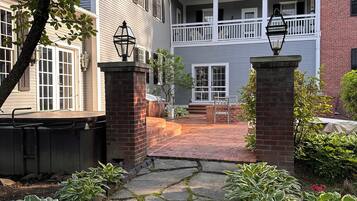 A stone pathway leading to a two-story building with a balcony.
