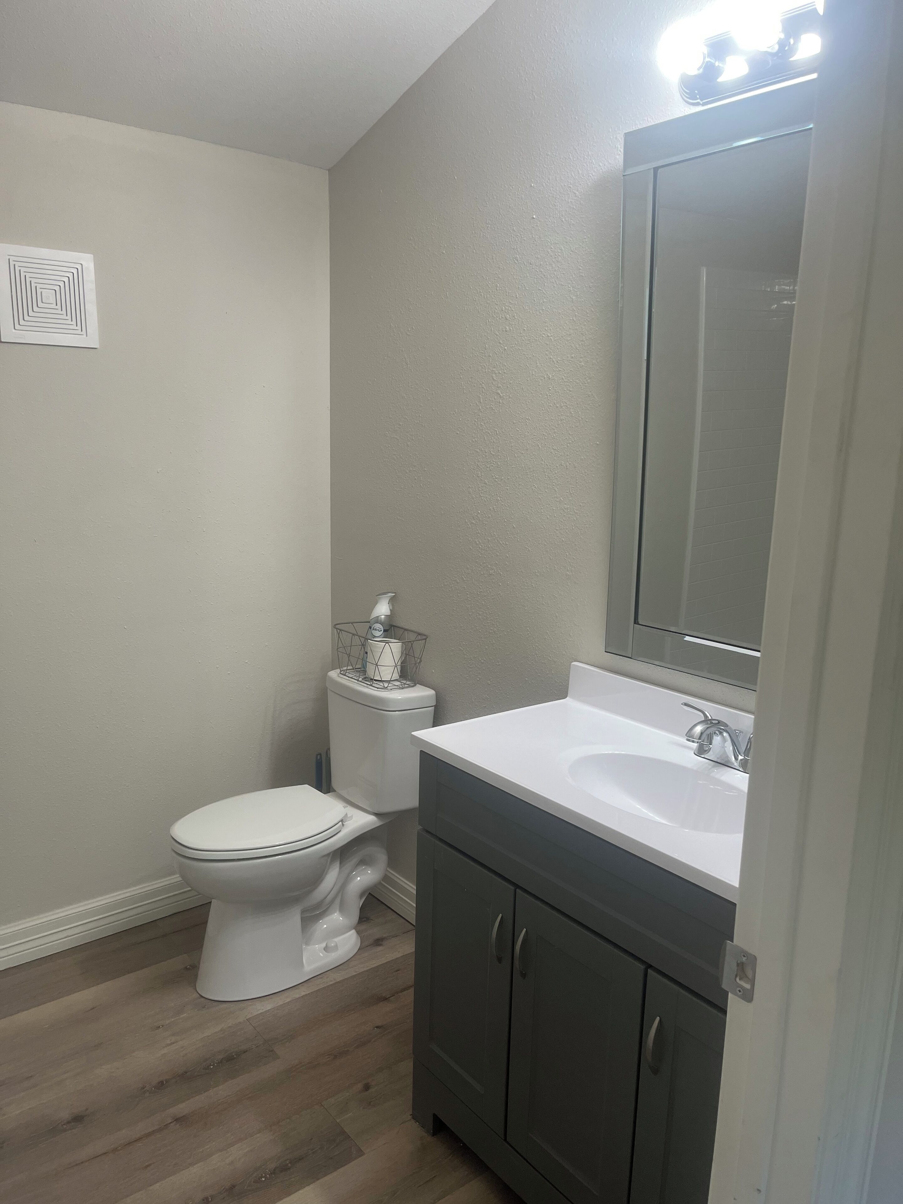 Une salle de bain avec des toilettes, un lavabo et un meuble de rangement.
