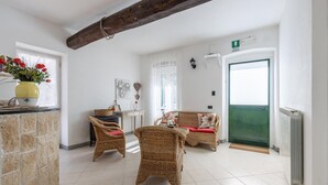 Una habitación acogedora con muebles de mimbre, un radiador y una puerta verde.
