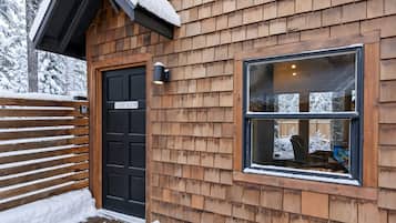 A wooden exterior with a black door labeled 'GAME ROOM' and a window with a view of a snowy landscape.