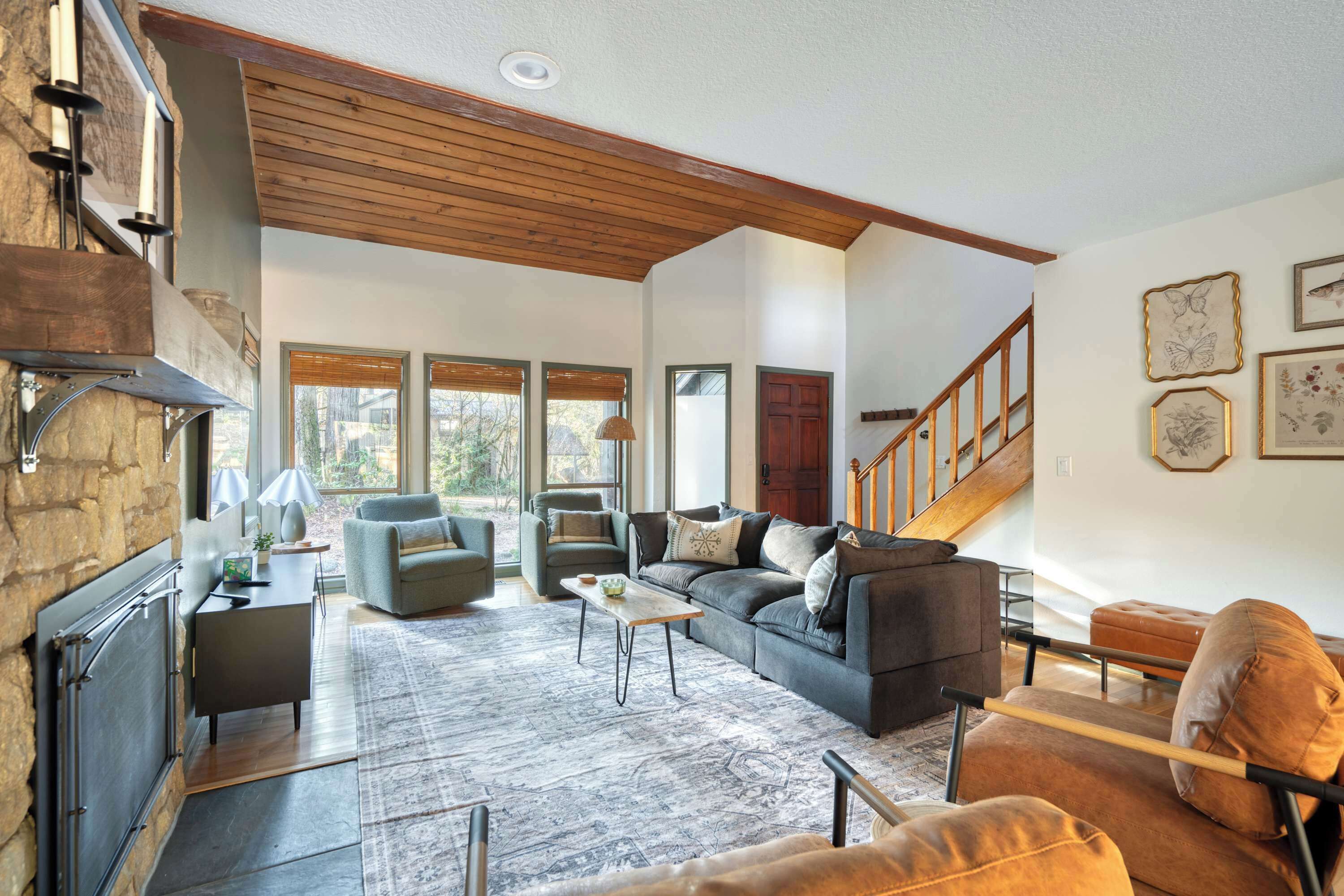 A spacious living room with a fireplace, a sofa set, a coffee table, and a staircase leading to another level.