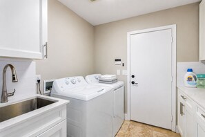 A laundry room with a washing machine, dryer, and a sink. - 3-bedroom Lake front villa in Casa Grande. with heated pool & spa. Kayak & bikes (Casa Grande)