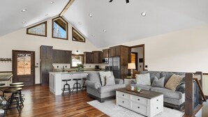 A spacious living area with a kitchen, a gray sofa, and a wooden coffee table.