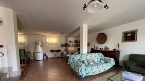 Ein großzügiger Wohnbereich mit einer Couch, einem Couchtisch und einer Küche im Hintergrund.