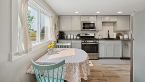 A modern kitchen with white cabinets, a stainless steel oven, and a microwave. - Charming barndominium with children's loft in quaint Middleton, Idaho (Caldwell)