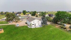 A single-story house with a fenced yard, a driveway, and a small garage. - Charming barndominium with children's loft in quaint Middleton, Idaho (Caldwell)