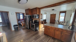 A spacious kitchen with wooden cabinets, stainless steel appliances, and a granite countertop. -  Authentic pioneer 
2 bedroom ranch farmhouse in beautiful Teton Valley Idaho. (Victor)