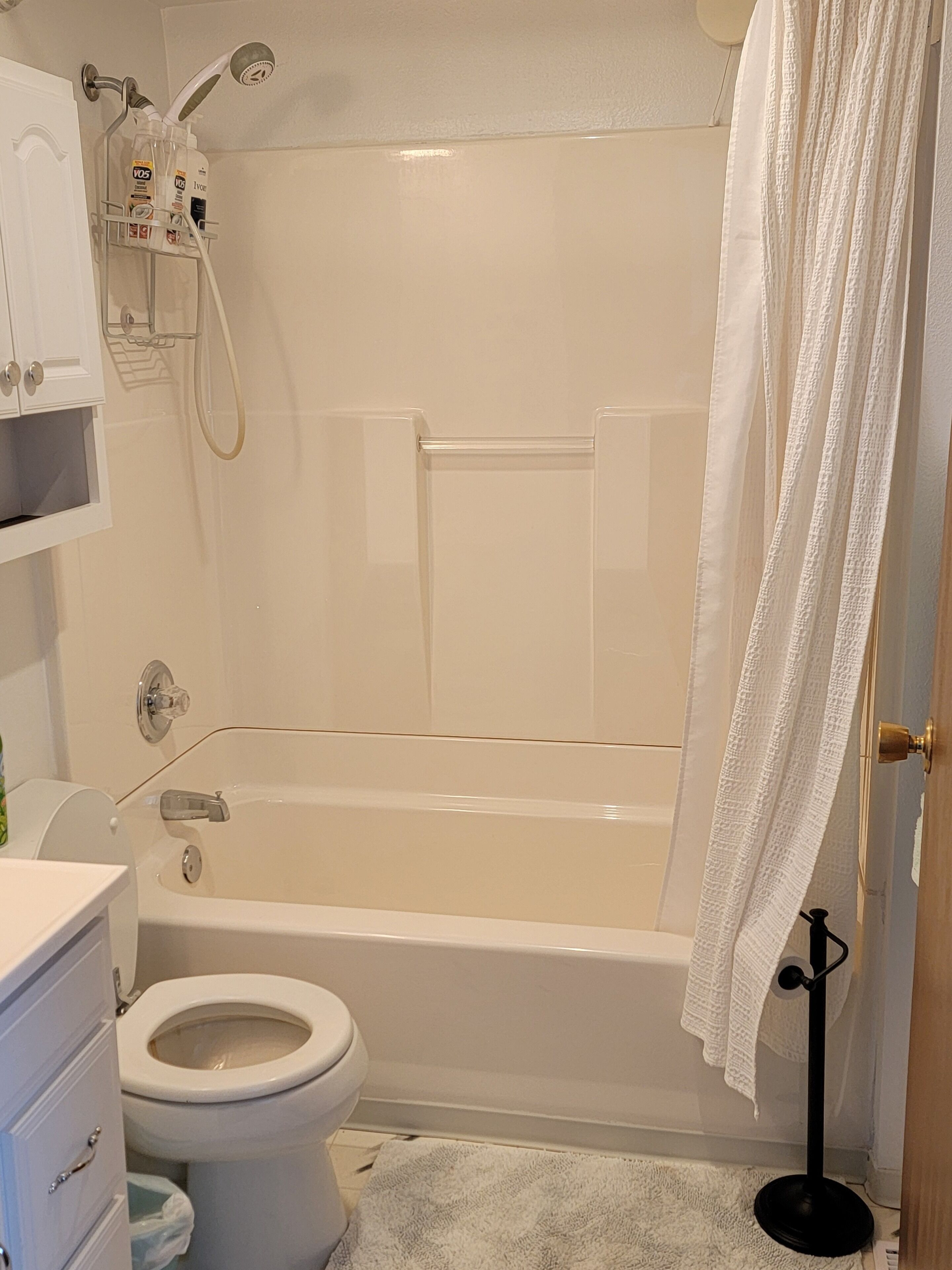 A bathroom with a bathtub, toilet, and a shower area.