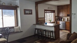 A compact living space with a kitchen area, a dining area with a window, and a sofa. -  Authentic pioneer 
2 bedroom ranch farmhouse in beautiful Teton Valley Idaho. (Victor)