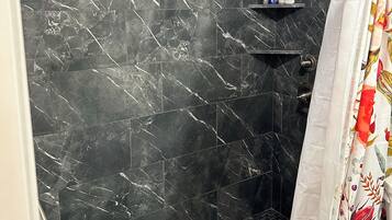 Chuveiro, toalhas de banho, papel higiênico