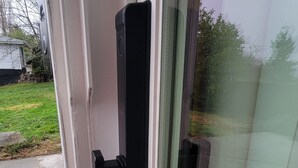 A glass door with a black handle and a latch.