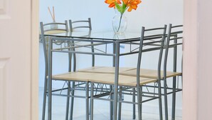 Ein Essbereich mit Tisch und Stühlen, einer Blumenvase und Pendelleuchten.