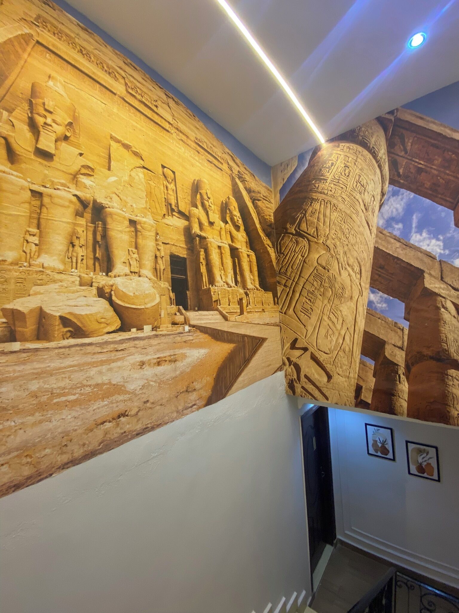 A wall mural of ancient Egyptian hieroglyphs and statues.