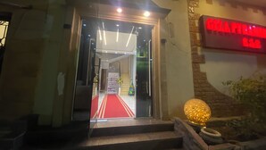 L'entrée d'un hôtel, avec un tapis rouge menant à un escalier.