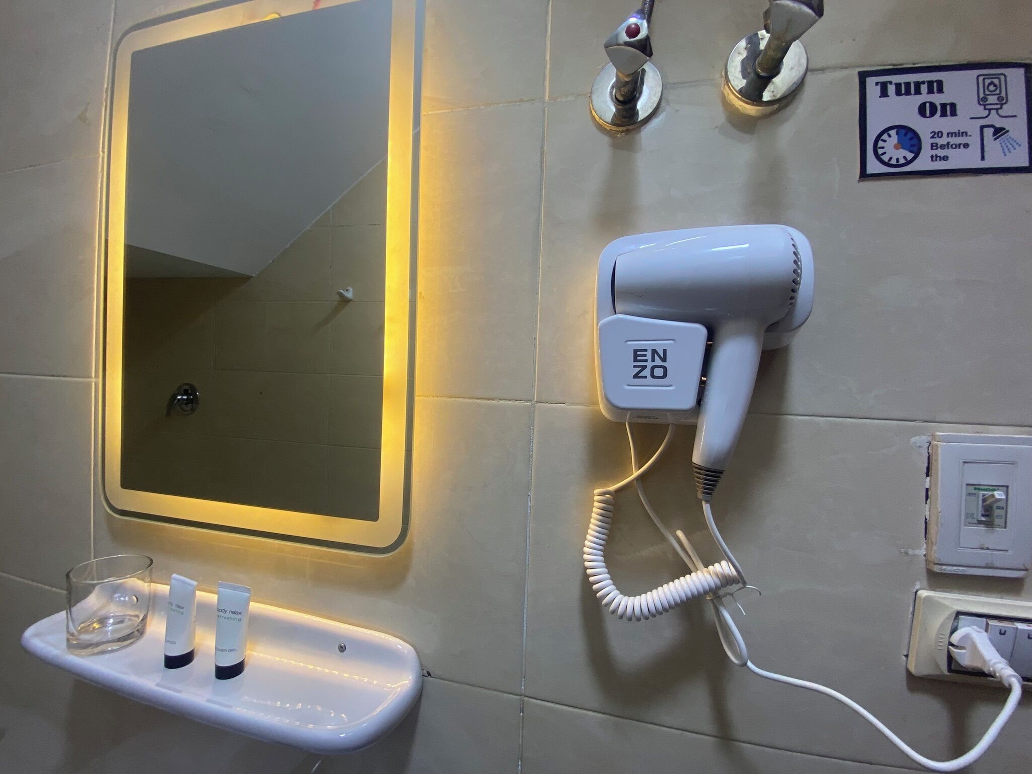 Un baño con espejo, secador de pelo y un perchero para toallas.