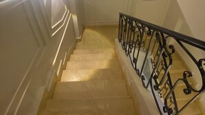 Un escalier doté d’une main courante et d’une source de lumière créant un effet de halo lumineux.