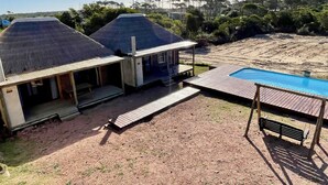 A two-story building with a pool and a covered patio area. - Amazing 2-bedroom bungalow with WiFi, AC in wonderful Punta del Diablo,Uruguay
 (Punta del Diablo)