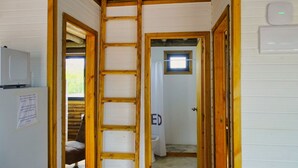 A narrow hallway with wooden doors leading to a bathroom and a small window. - Amazing 2-bedroom bungalow with WiFi, AC in wonderful Punta del Diablo,Uruguay
 (Punta del Diablo)