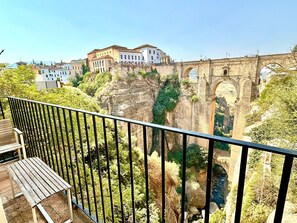 A balcony with a view of a historic stone bridge and buildings.