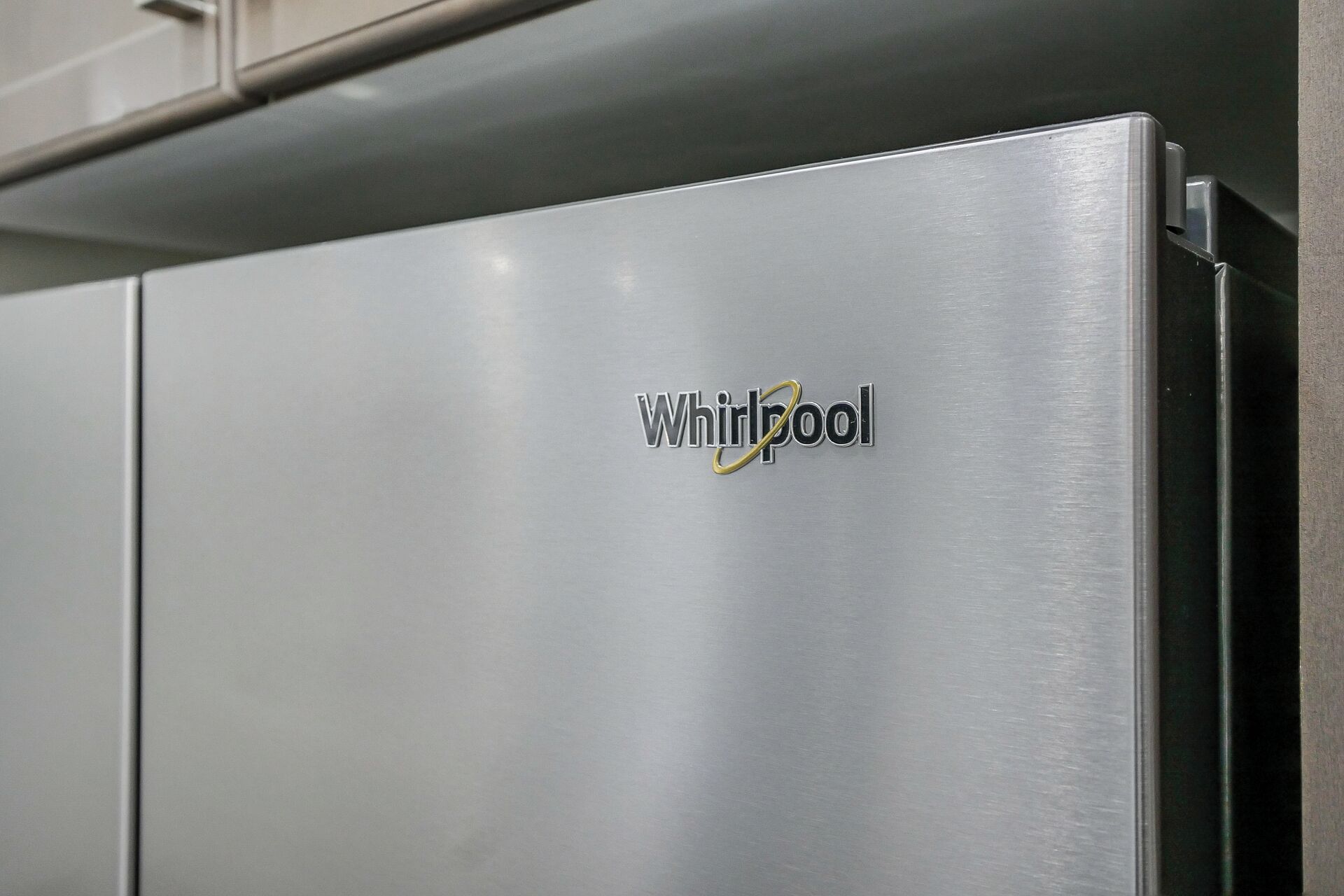 A stainless steel Whirlpool refrigerator with a visible brand logo.