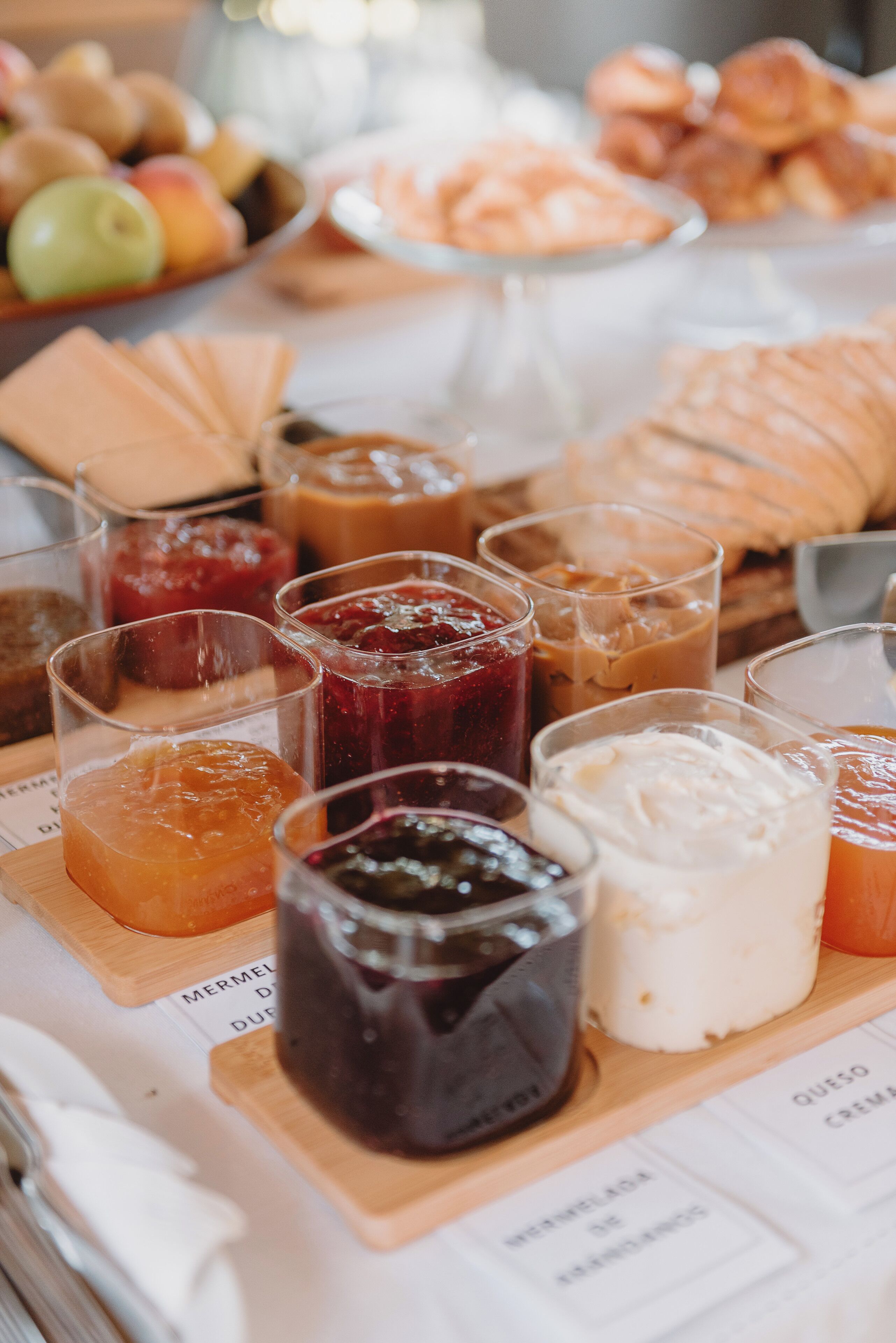 Una mesa con diversas opciones de comida, como frutas, pasteles y salsas.